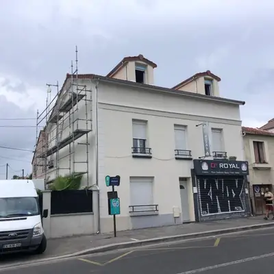 Immeuble d'angle avec échafaudage installé sur la façade latérale pendant le ravalement