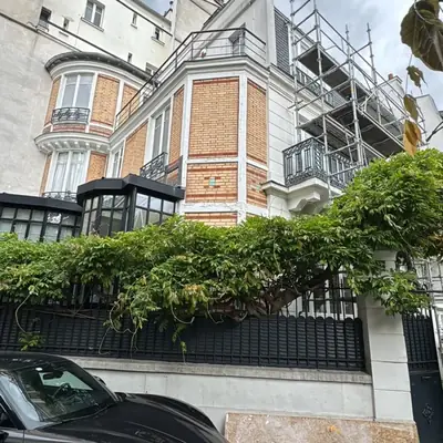 Façade en brique et pierre d'une maison de maître avec échafaudage de ravalement