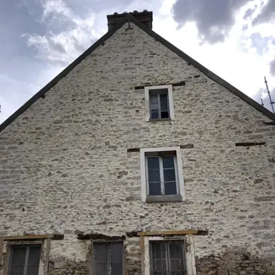 Pignon d'une maison ancienne en pierre apparente, joints repris à la chaux par PRBTP