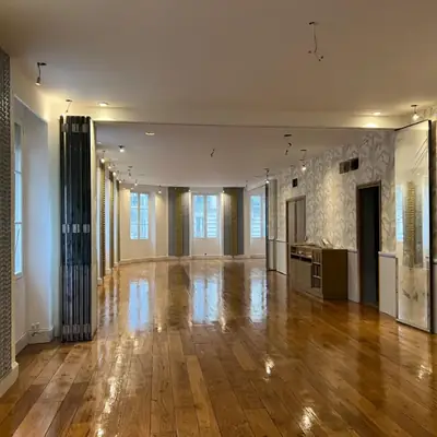 Salle rénovée avec parquet, papier peint, menuiseries et éclairage sur rail