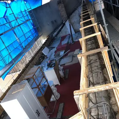 Chaînage en béton armé ferraillé et coffré en attente de coulage