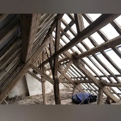 Charpente traditionnelle en bois ancien mise à nu avant travaux de couverture