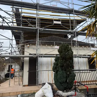 Pavillon entouré d'un échafaudage avec plancher de travail pour la réfection de sa toiture